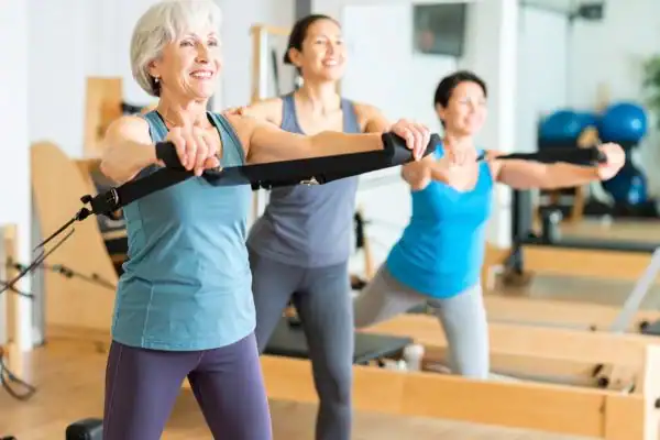 Toning Arms After 60: Empowering Womens Fitness Through Effective Weight Training 2 older woman doing weight training Yorkshire and resistance in the gym to tone upper arms