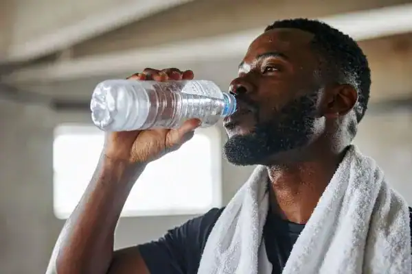Image of man drinking water to improve hydration Yorkshire after work out.